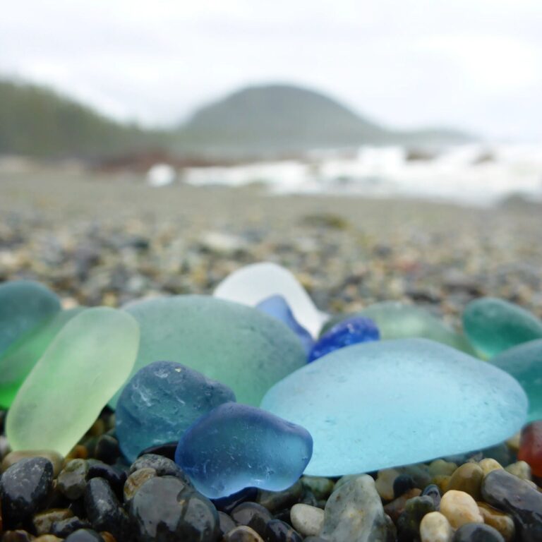 blue and green seaglass nested on a gravel beach