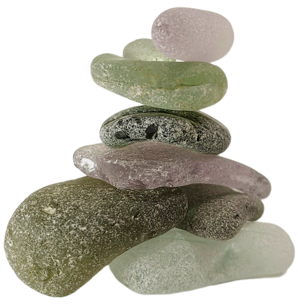 A stacked cairn of purple and green sea glass